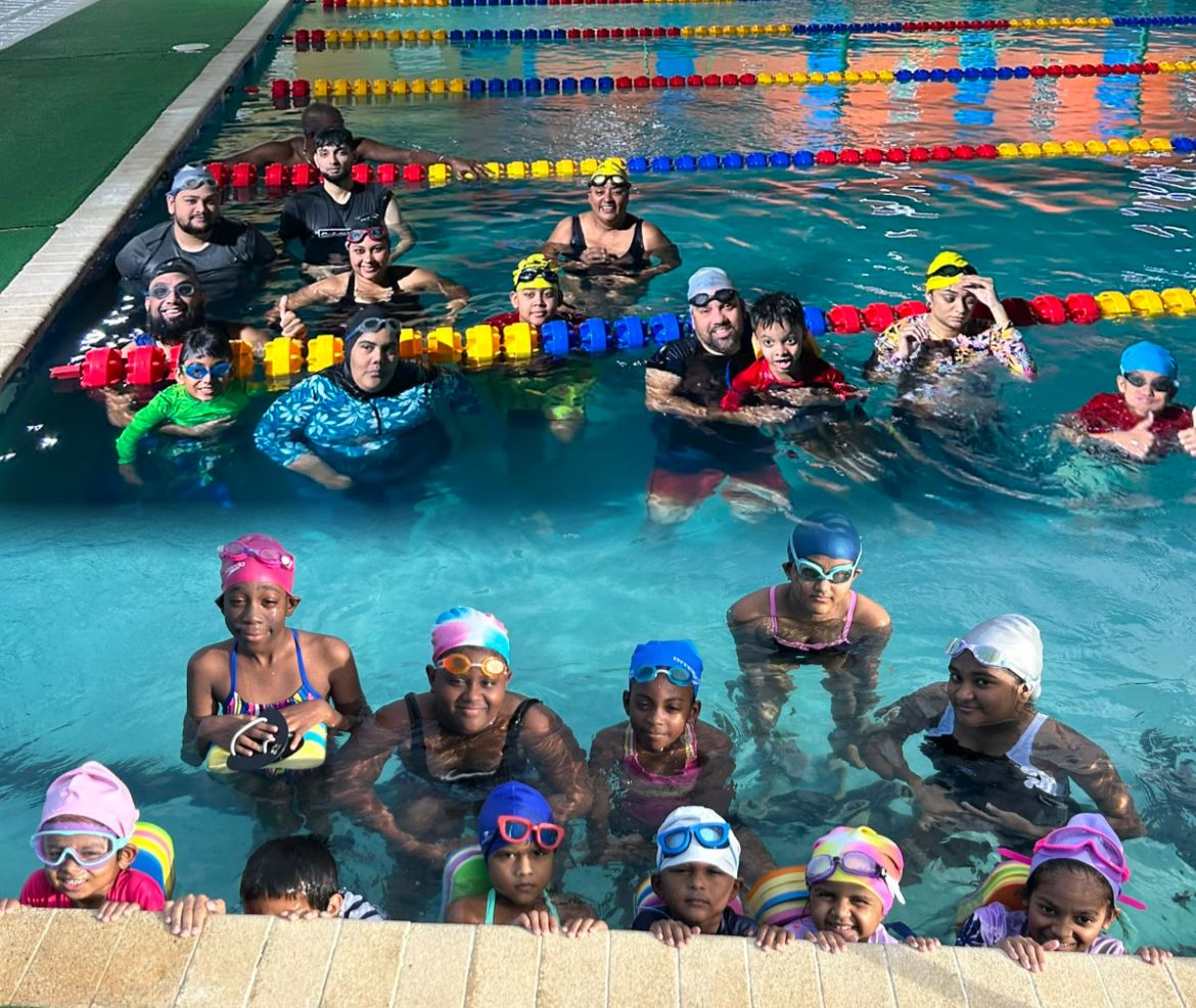 Timmy's Swimming students smiling together in the pool